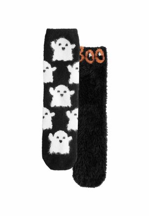 Ett par svarta fluffiga strumpor; en strumpa har vita spökmönster, den andra har "Boo" skrivet i orange nära toppen.