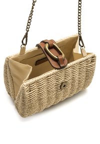 Bolso de paja tejido en beige con una correa de cuero marrón, herrajes de bronce y cierre de botón magnético. Interior forrado con bolsillos abiertos.