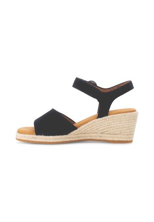 Sandale noire à talon compensé avec une semelle de style espadrille. Elle présente deux larges brides et une bride arrière pour le soutien, avec une finition lisse.