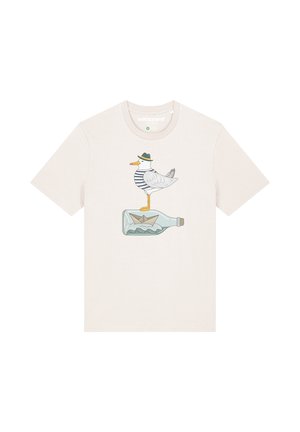 Beige cotton t-shirt featuring a graphic of a seagull in a striped shirt and hat, standing on a bottle with a paper boat inside.