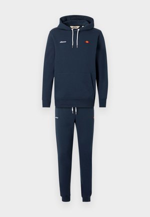 Conjunto de sudadera con capucha y pantalones deportivos azul marino con cordones blancos, bolsillo frontal y pequeños logotipos de ellesse en el pecho y el muslo.