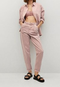 Camisa de denim rosa, top corto a juego y pantalones de cintura alta con puños doblados. Sandalias negras completan el look. Textura suave.