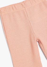 Leggings de color rosa con textura acanalada, que cuentan con una cinturilla elástica, suave al tacto y con un diseño ajustado. Ideales para un uso cómodo.