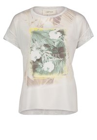 Hellgraues, kurzärmliges Oberteil aus glattem Stoff mit einem tropischen Muster, weißen Blumen und Text, umrandet von einem gelben Rahmen.