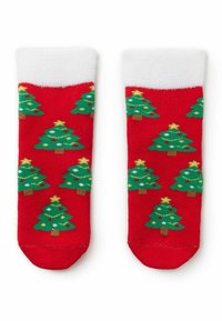 Červené ponožky s opakujícími se zelenými vánočními stromy se žlutými hvězdami a barevnými ozdobami, a měkkým bílým lemem na vrchu.