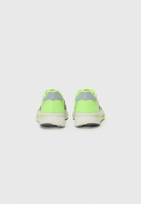 Neon groene sportschoenen met grijze accenten, bovenkant van mesh, gevoerde kraag en een dikke witte zool. De achterkant toont het ontwerp en de materialen.
