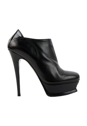 Schwarzer Leder-Plateau-Knöchelstiefel mit hohem Absatz, spitzer Schuhspitze und glänzendem Abschluss am Fersenbereich.