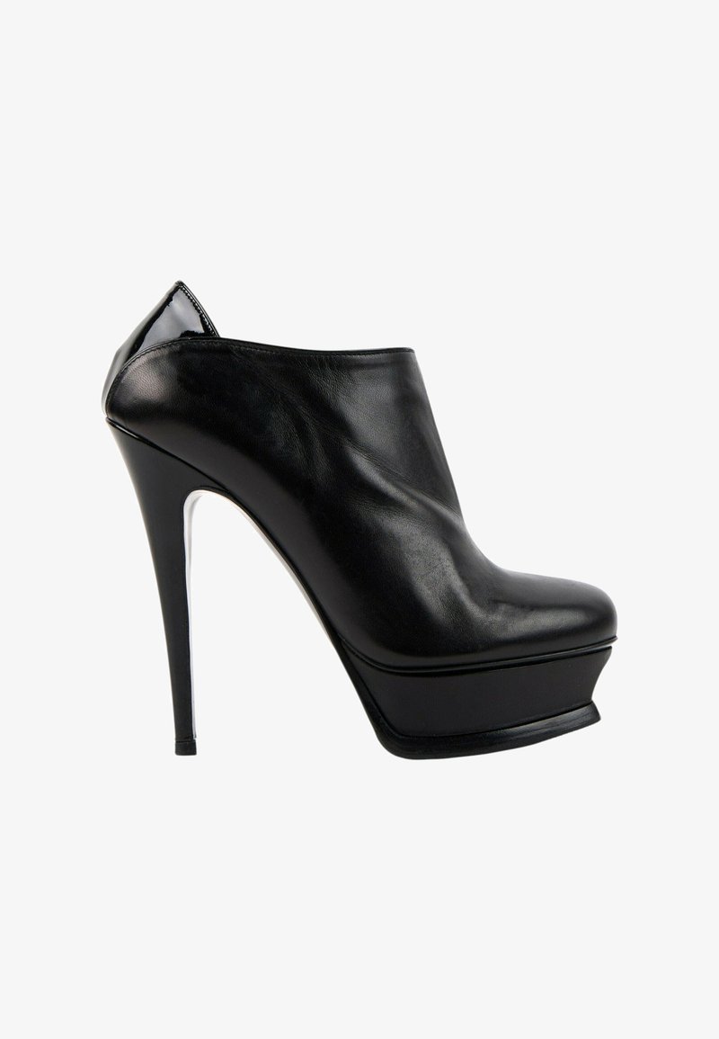 Bottine en cuir noir à talon haut avec plateforme, bout pointu et finition brillante sur le contrefort du talon.