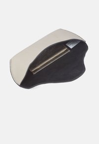 Läderpung i ljusbeige med en mjuk svart insida. Har en slät yta och en böjd övre kant. Innehåller en sektion med guldaccent.
