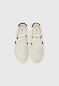 White leather sneakers with navy accents, flat laces, padded collar, and embossed logo on the tongue. Smooth surface with minimal detailing.