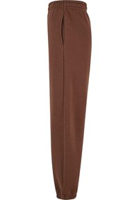 Bruine sweatpants van zachte stof, met een elastische tailleband, zijzakken en taps toe lopende pijpen voor een comfortabele pasvorm.