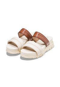 Vita plattformssandaler i vitt med två breda, bruna läderliknande remmar med krokodilmönster. Mjuk vadderad sula och slitstark gummiyttersula.