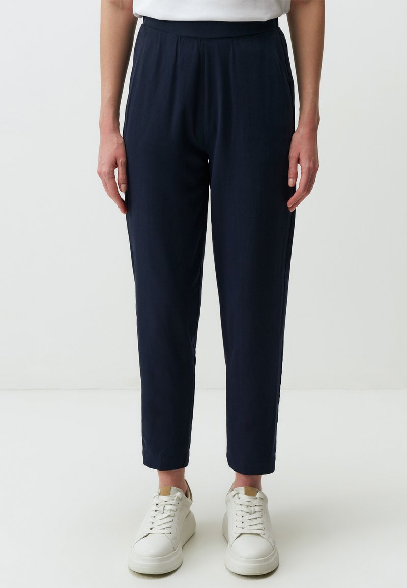 Marine casual broeken met een relaxed fit, elastische tailleband en zijzakken. Gecombineerd met witte sneakers voor een minimalistische uitstraling.
