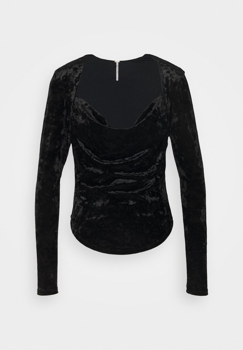 T-shirt long en velours noir à encolure dégagée, avec des détails froncés et un ourlet légèrement courbé. Fermeture zippée au dos.