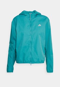 Giacca leggera color teal con cappuccio, zip frontale e maniche lunghe. Presenta un logo discreto sul petto. Tessuto morbido e materiale resistente all'acqua.