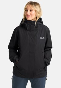 Schwarze wasserdichte Jacke mit hohem Kragen und verstellbarer Kapuze. Verfügt über Reißverschlusstaschen und ein minimalistisches Logo auf der Brust.