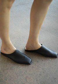 Černé, lehké boty na slip-on s designem �čtveraté špičky a hladkým povrchem, s otevřenou patou a minimalistickým stylem.