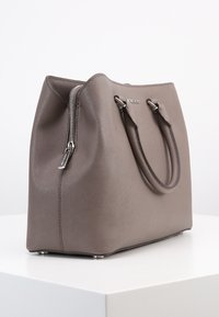 Grijze synthetische handtas met een ritssluiting, twee bovenhandgrepen en zilverkleurige hardware accenten. Gladde textuur en gestructureerd ontwerp.