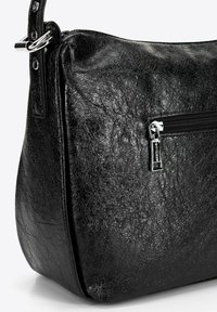 Černá syntetická kabelka s krčivou texturou, s kapsou na zip a stříbrnými kovovými prvky, zobrazená z úhlového bočního pohledu.