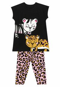Schwarzes Kurzarmoberteil mit Cartoon-Tieren und rosa Akzenten; kombiniert mit rosa Leggings mit einem schwarzen und goldenen Leopardenmuster.