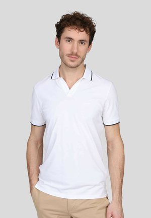 Chemise polo blanche avec un col en V, ornée de bordures bleu marine le long du col et des manches. Tissu lisse avec une coupe ajustée.