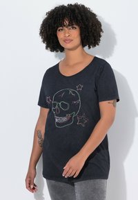 T-shirt en coton noir avec un col rond, arborant des motifs de crânes et d'étoiles multicolores brodés. Coupe décontractée avec des manches courtes.
