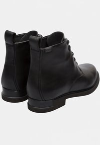 Stivali alla caviglia neri in pelle con lacci e linguette, con tacco basso e un piccolo etichetta Gore-Tex sul lato.