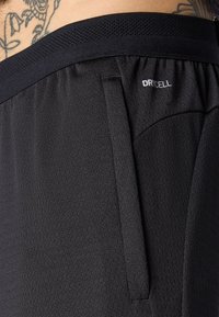 Sorte sportsshorts i tekstureret stof, med elastisk talje og mesh, samt en lomme med et DRYCELL-logo.