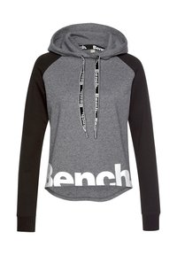 Sweat à capuche gris et noir avec une poche kangourou, présentant des manches contrastantes, une capuche à cordon et un grand logo blanc "Bench" sur le devant.