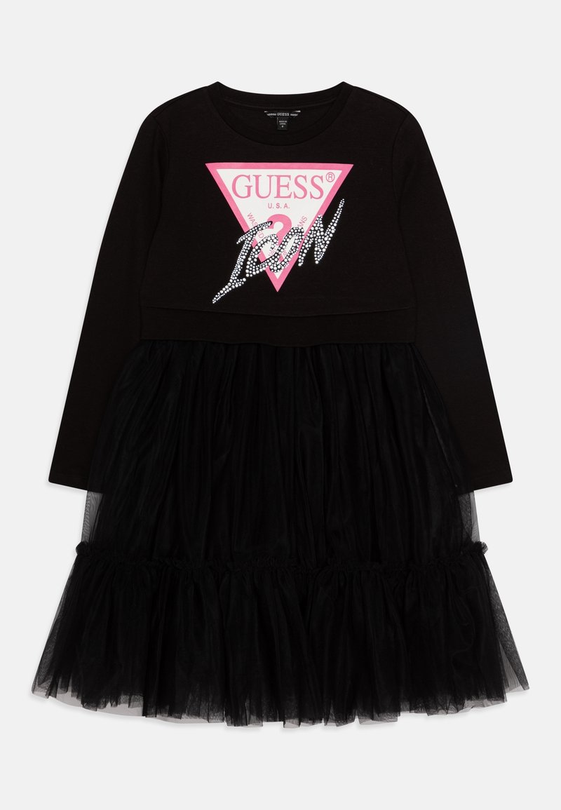 Robe noire à manches longues avec une jupe en tulle superposée et un logo Guess USA rose avec le texte "Icon" sur la poitrine.