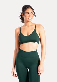 Zielony sportowy krótki top z cienkimi ramiączkami, zaokrąglonym dekoltem i gładką fakturą, zestawiony z dopasowanymi legginsami z wysokim stanem.