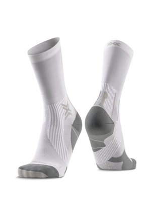 Par de calcetines deportivos blancos de caña media con detalles grises en talones, dedos y arcos sobre un fondo blanco.