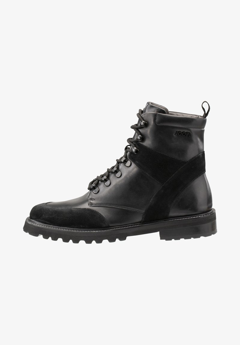 Schwarzer Leder- und Wildleder-Ankle-Boot mit runder Spitze, sechs Ösen, gepolstertem Kragen und robustem Gummisohle für besseren Halt. Markenlogo sichtbar.