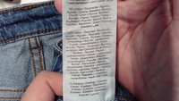 Džinsu auduma sastāvs uz etiķetes: 79% kokvilna, 20% pārstrādāta kokvilna, 1% elastāns vairākās valodās.