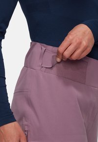 Light purple pants with a smooth texture, featuring a velcro closure at the waist and a side zipper pocket.