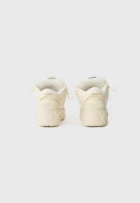 Kremfargede sneakers med rund form, gummisåler og subtile merkevarer detaljer på hælen. Glatt tekstur med polstret krage.