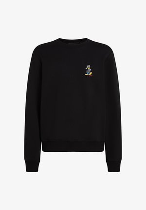 Mustmustriid särk, millel on ümar kaelus, pikad varrukad, soonikvarrukad ja -äär; vasakul rinnal on väike tikitud tegelane.