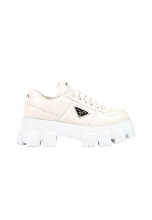 Baskets en cuir blanc Prada avec semelle épaisse rainurée, lacets à l’avant et plaque triangulaire noire du logo sur le côté.