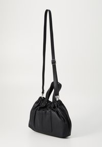 Zwarte leren tas met een geraffineerd ontwerp, verstelbare schouderband en zilverkleurige hardware. Voorzien van een voorvak en een glad, textuur oppervlak.