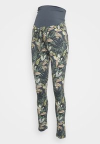 Těhotenské legíny s tmavě šedým elastickým pasem, zdobené potiskem tropického listí v zelené, béžové a krémové barvě na černém pozadí.