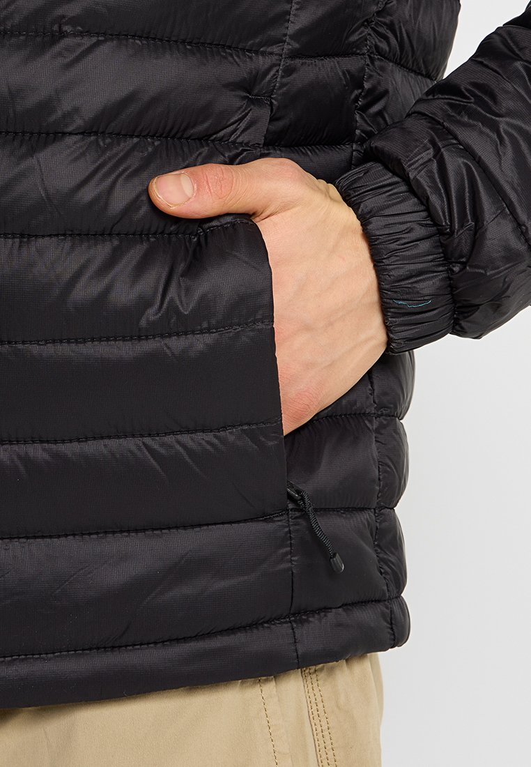 Czarna, pikowana kurtka z poziomym przeszyciem, z boczną kieszenią i elastycznymi mankietami. Materiał ma gładką, błyszczącą teksturę.