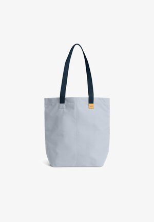 Borsa tote in tela azzurro chiaro con manici blu scuro, forma quadrata e una piccola etichetta arancione del marchio sul davanti. Design semplice e funzionale.