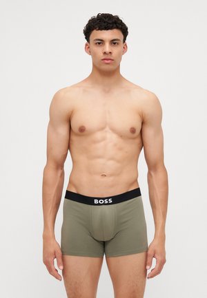 Tamnozeleni bokserice s crnim pojasom na kojem se nalazi bijeli logo "BOSS." Tkanina izgleda glatko, prilagođeno i elastično.