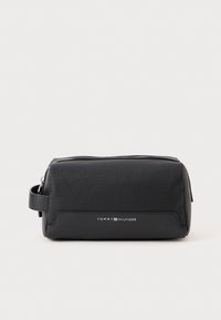 Black toiletry bag made of textured material with a zip closure, featuring a side handle and a white logo on the front. Compact design.