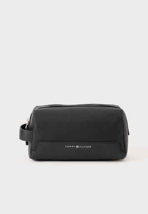 Black toiletry bag made of textured material with a zip closure, featuring a side handle and a white logo on the front. Compact design.