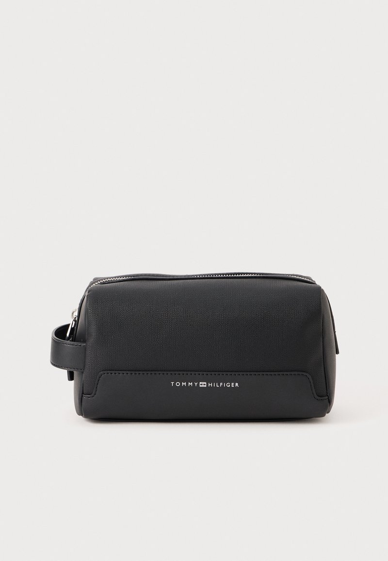 Black toiletry bag made of textured material with a zip closure, featuring a side handle and a white logo on the front. Compact design.