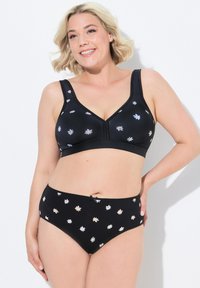 Svart bralette och matchande trosor med blommig broderi. V-ringad design med mjukt tyg och justerbara band. Broderiet har ljusa färger.