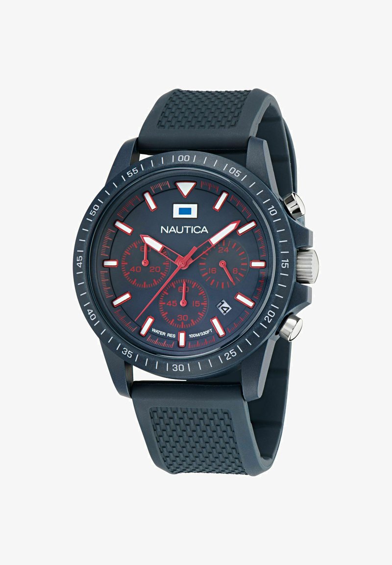 Nautica pulkstenis ar tumši zilu gumijas siksniņu, apaļu korpusu, sarkaniem akcentiem un melnu ciparnīcu, kurā ir luminiscējošas rokas un trīs hronogrāfa subdiali.