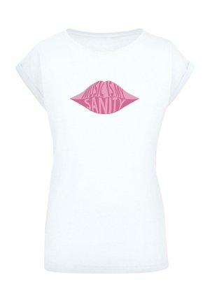 T-shirt bianco in cotone con maniche corte arrotolate. Presenta una grafica di labbra rosa e il testo "LA MUSICA È LA MIA SANITÀ" in grassetto, con carattere stilizzato.