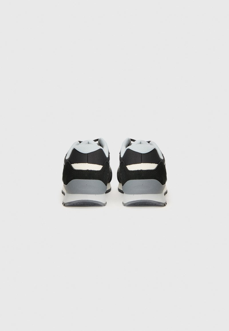 Schwarze und graue Sneakers mit einem Obermaterial aus Mesh und Suedeverzierungen. Sie haben eine abgerundete Zehenpartie und eine gepolsterte Sohle. Reflektierendes Detailstreifen auf der Rückseite.